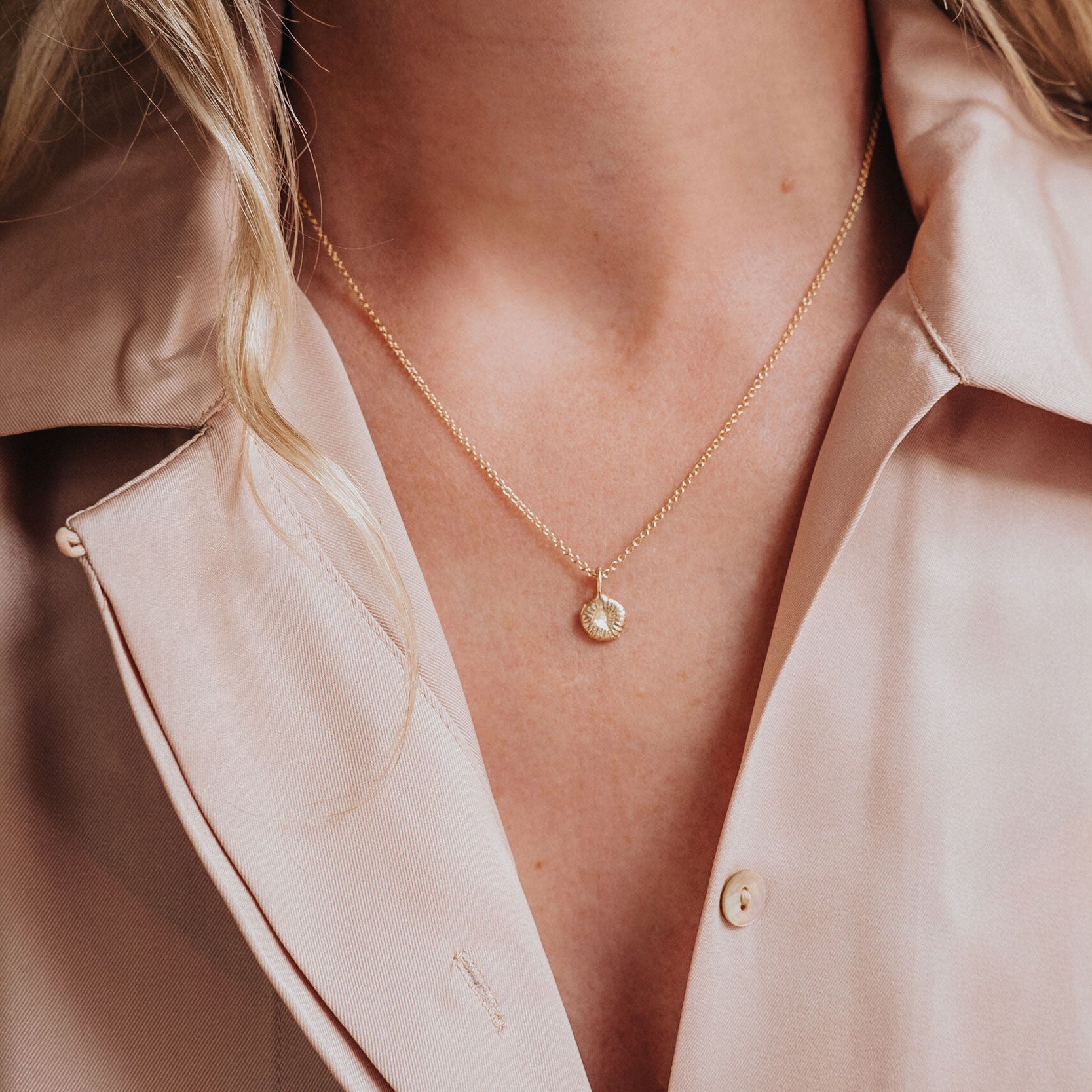 Guldhalsband med knappkorall på modell