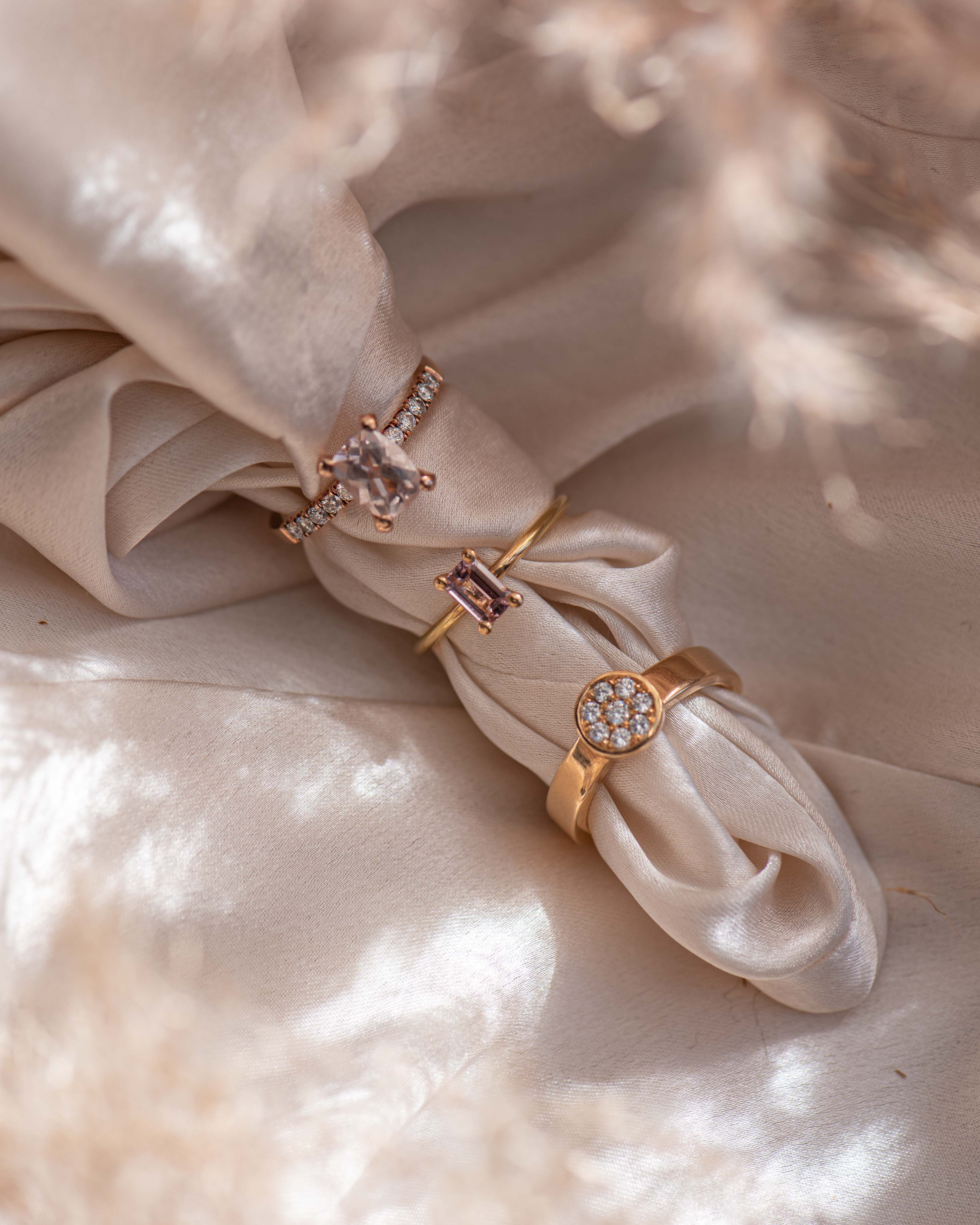 Alt-text:Eleganta guldringar med diamanter på sidenbakgrund