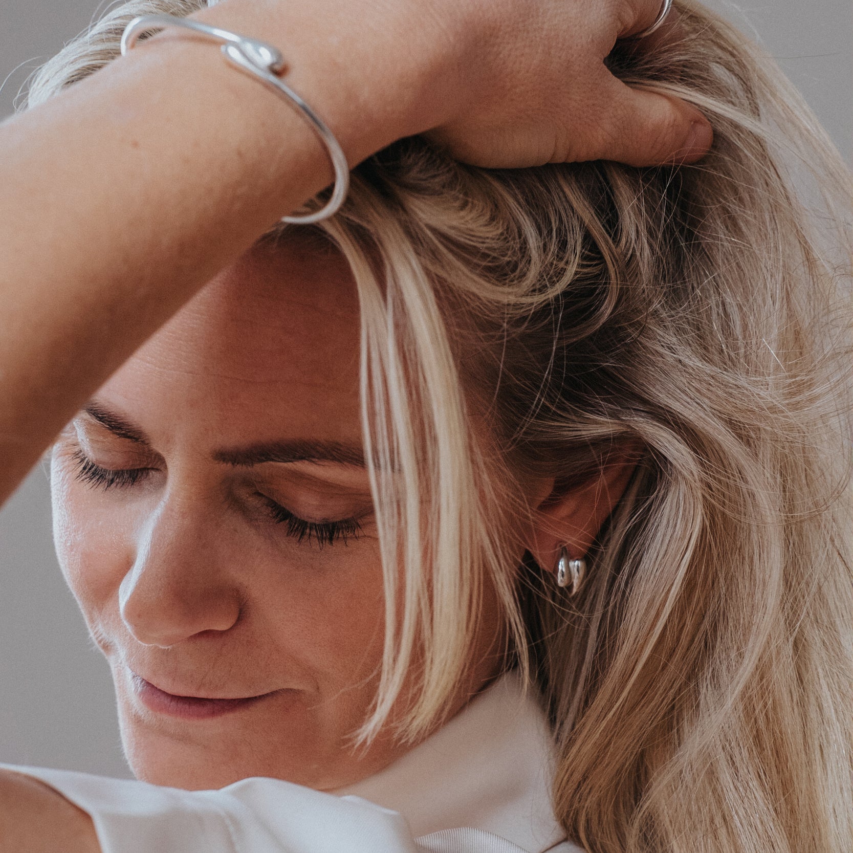 Kvinna bär Got Your Back örhänge i silver