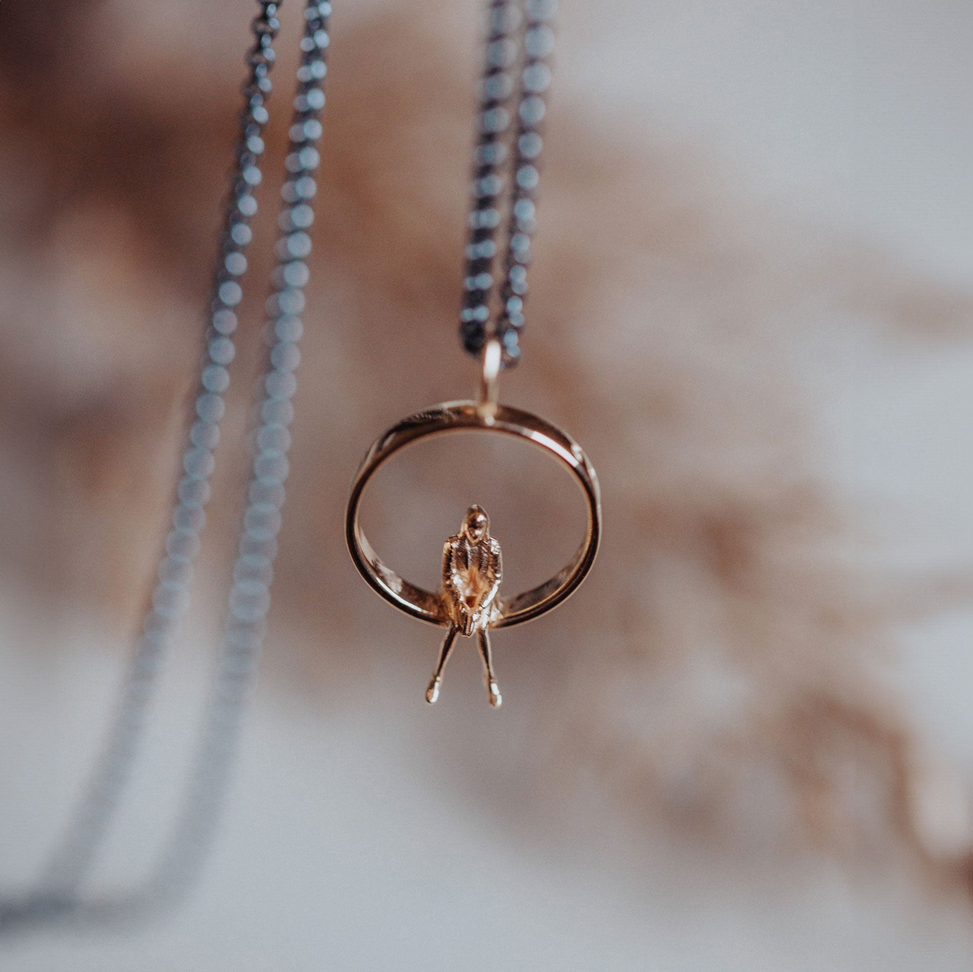 Detalj av Egentid berlock i 18k guld