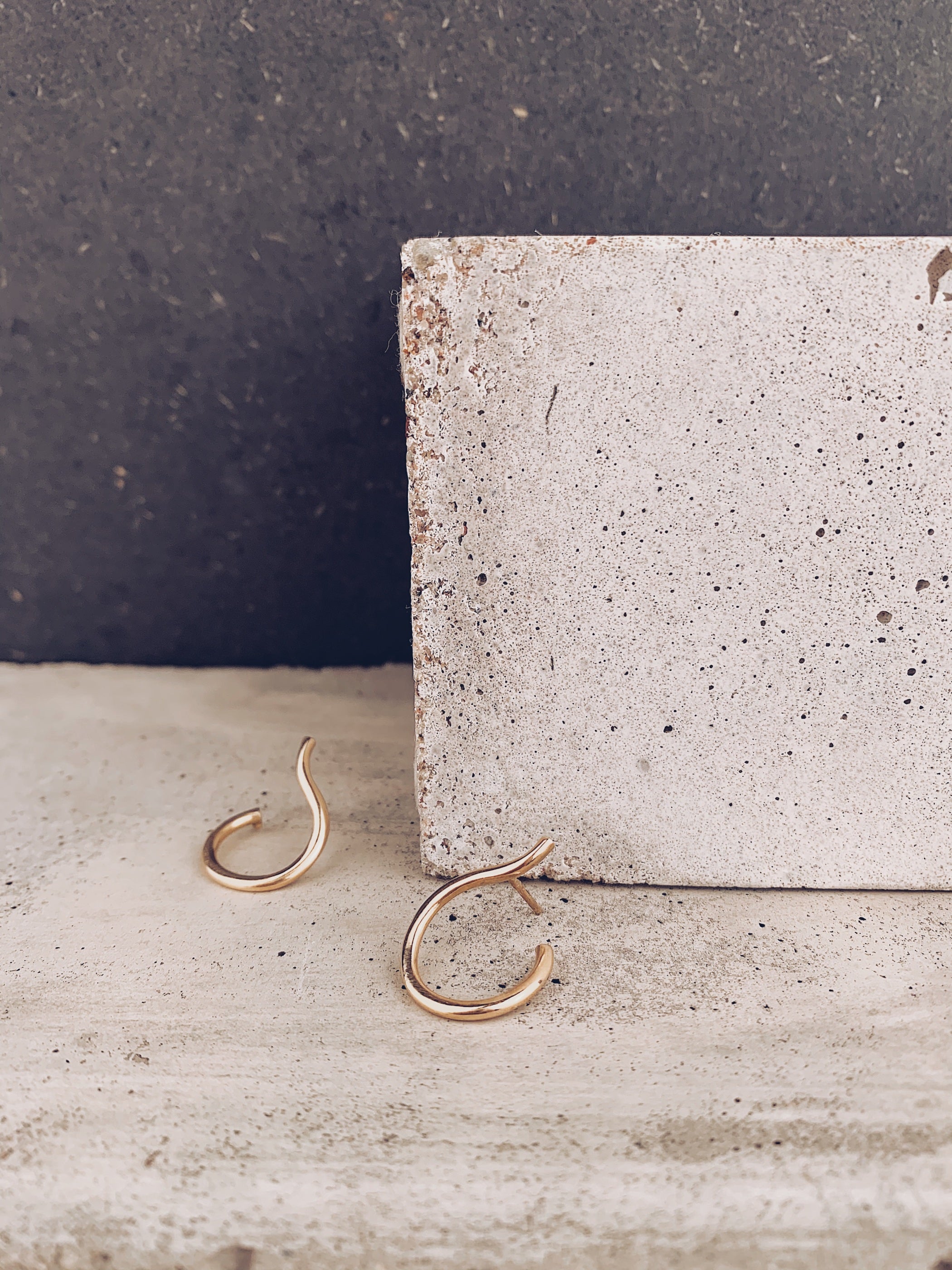 Martall stora örhängen i guld mot rustik bakgrund