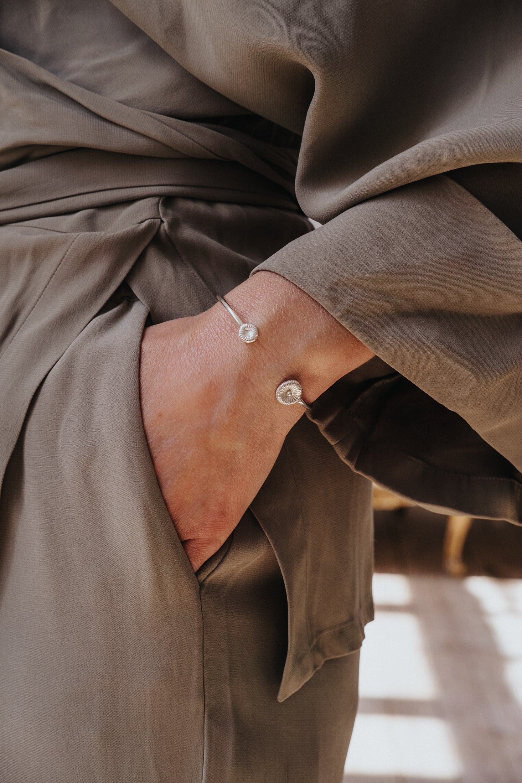 Knappkorall armband i silver på hand i grön klänning